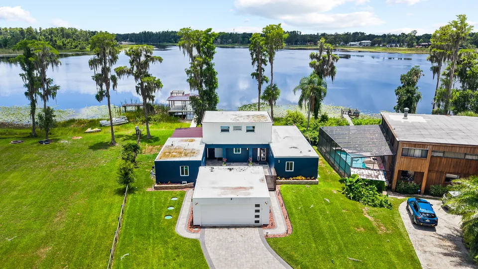 Aerial view of the home, pool and lakefront setting