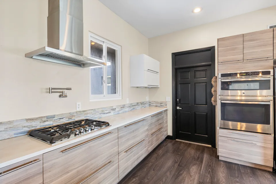 Kitchen cooktop, pot filler, granite counters and tile backsplash