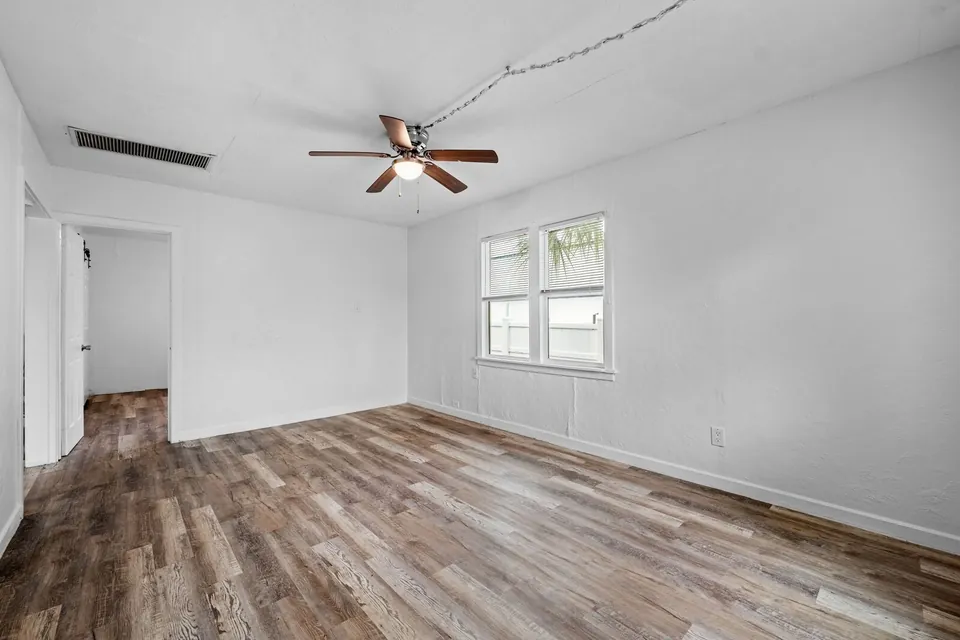 Living room with ceiling fan and wood-look floor