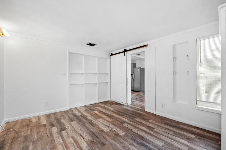 Bedroom with built-in shelves and sliding barn door