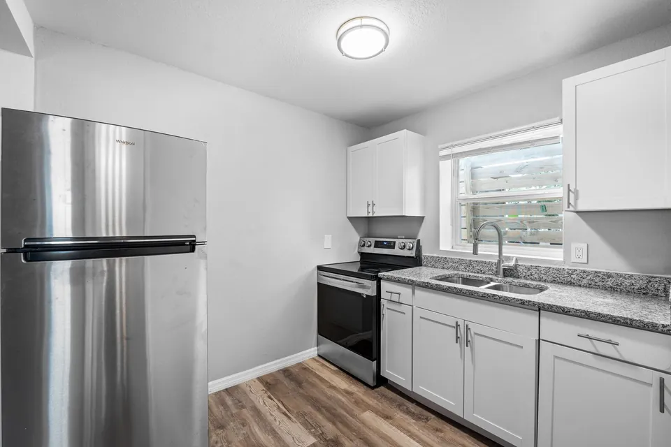 Kitchen with white cabinets and black range