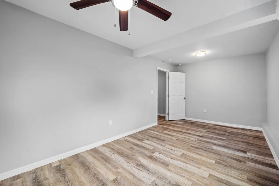 Bedroom with wood-look floor and ceiling fan