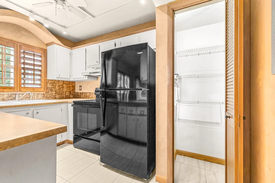 Kitchen with white cabinetry and black refrigerator