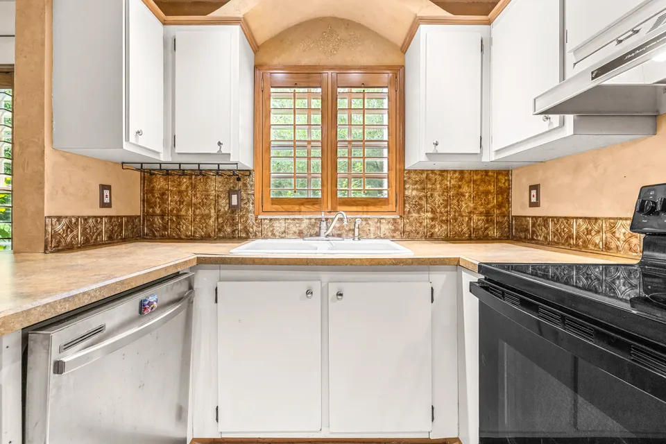 Tiled kitchen with white cabinets