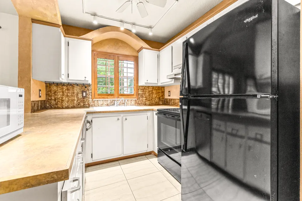 Galley kitchen with range and refrigerator
