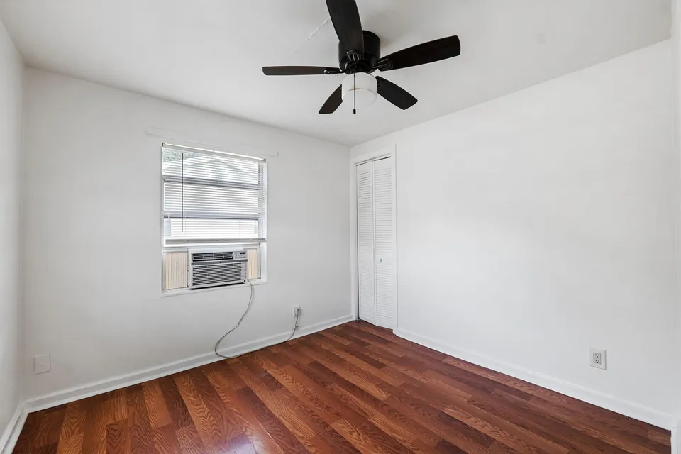 Bedroom with ceiling fan and wall air conditioner