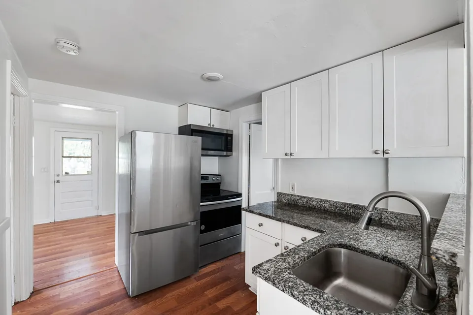Kitchen with stainless refrigerator and black range