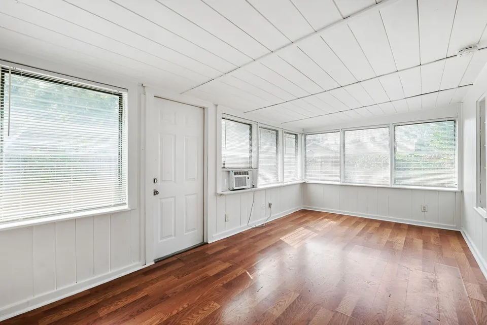 Enclosed porch with windows and wood floor
