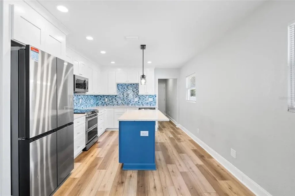 Kitchen with central island and white cabinetry at 5907 N Ola Avenue