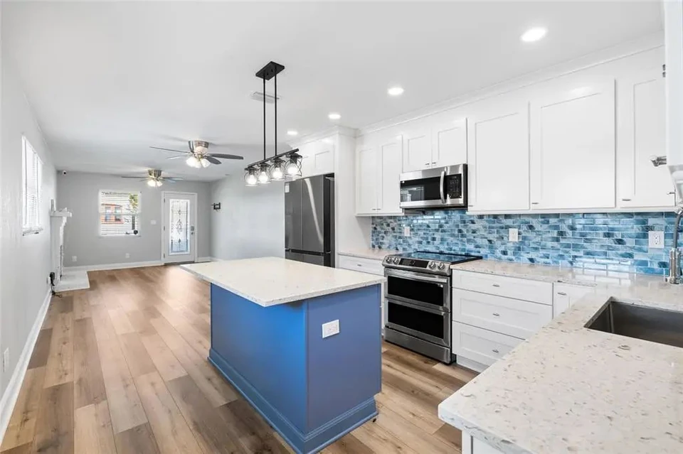 Kitchen island, cabinetry and adjoining living area at 5907 N Ola Avenue