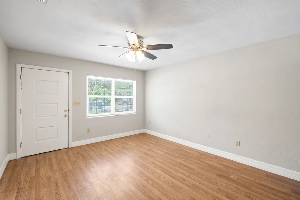 Living room with ceiling fan and wood-look floor