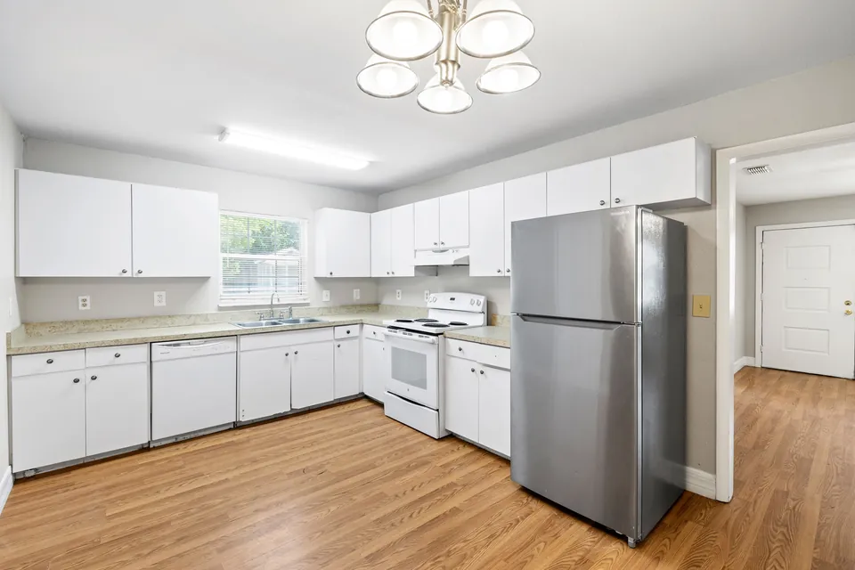 Kitchen with white cabinets and stainless refrigerator