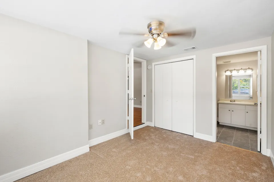 Bedroom with carpet and adjacent bathroom