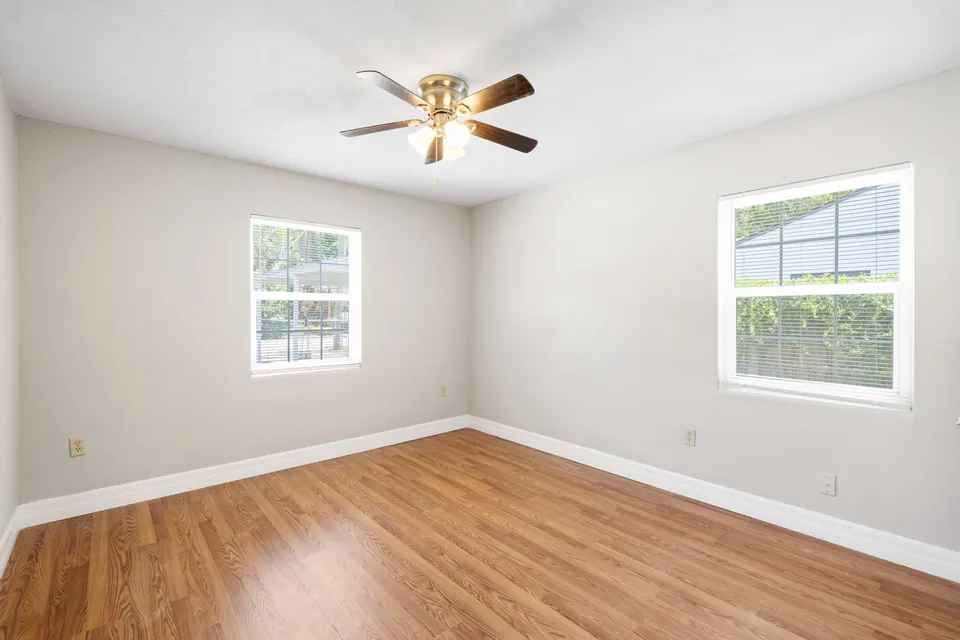 Bedroom with two windows and wood-look floor