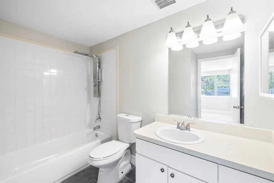 Bathroom with tub-shower and white vanity