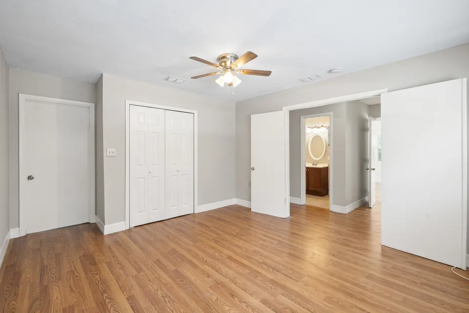 Large bedroom with closets and bathroom entry