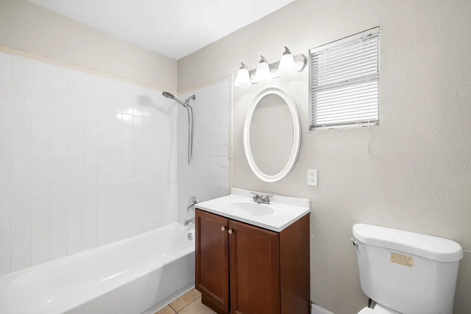 Bathroom with tub-shower and dark wood vanity